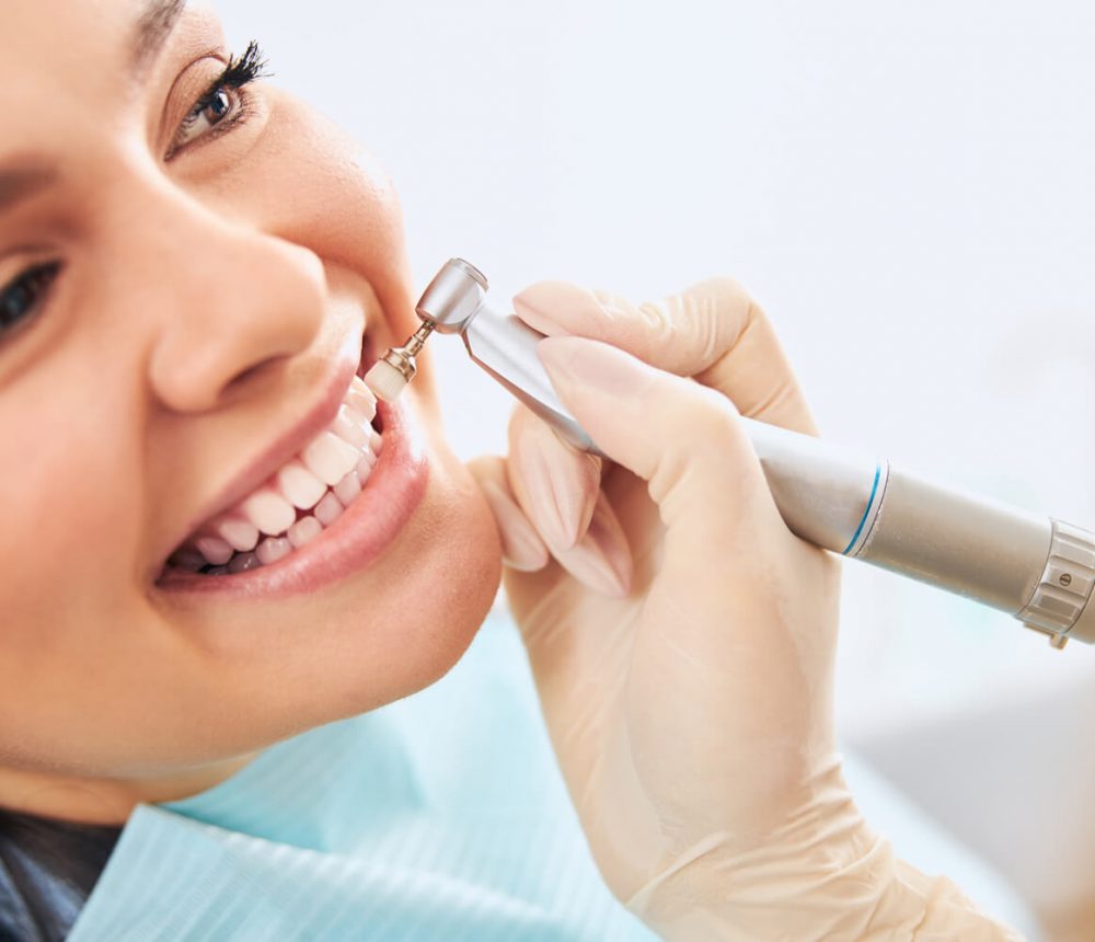Nahaufnahme von Frau mit weißen Zähnen beim Zahnarzt Desinger